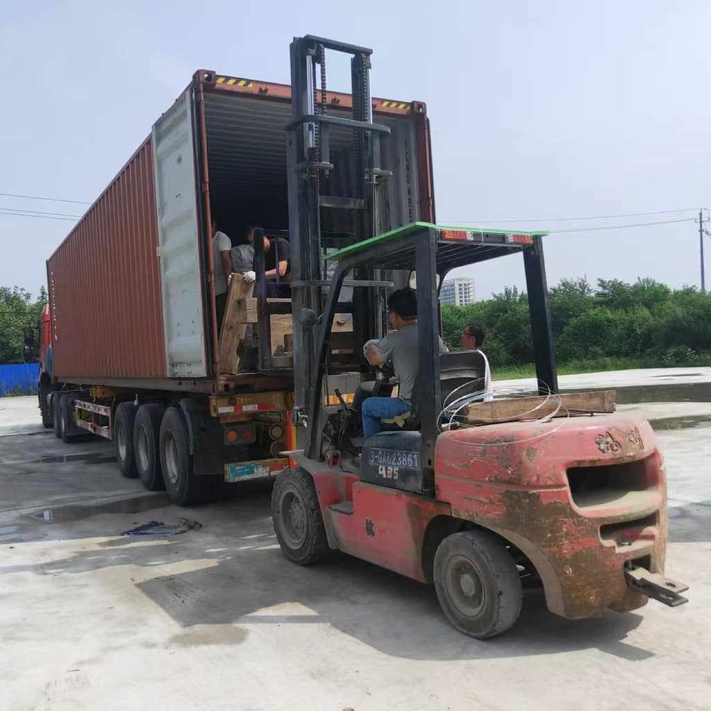 Νταλίκα με ανοιχτό container και κλαρκ που φορτώνει κιβώτια στην αυλή φόρτωσης