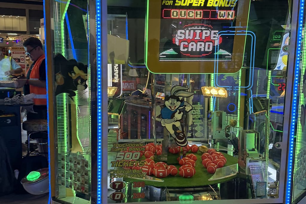 Γερανάκι δώρων (crane machine) με φωτισμένη οθόνη σκορ και λούτρινα, στην IAAPA Expo Europe 2025