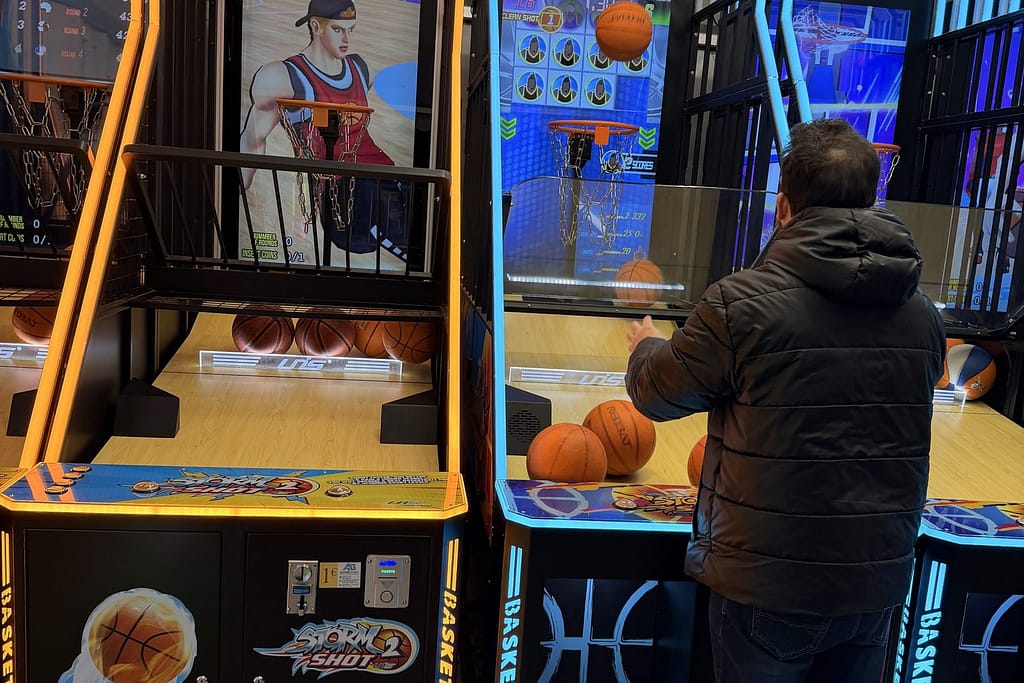 Επισκέπτης παίζει σε ηλεκτρονική μπασκέτα arcade με κερματοδέκτη στα Χριστούγεννα της Αριστοτέλους