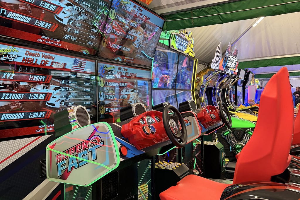 Σειρά από καθιστά racing arcade simulator με κόκκινα καθίσματα και οθόνες, σε τέντα στην πλατεία Αριστοτέλους