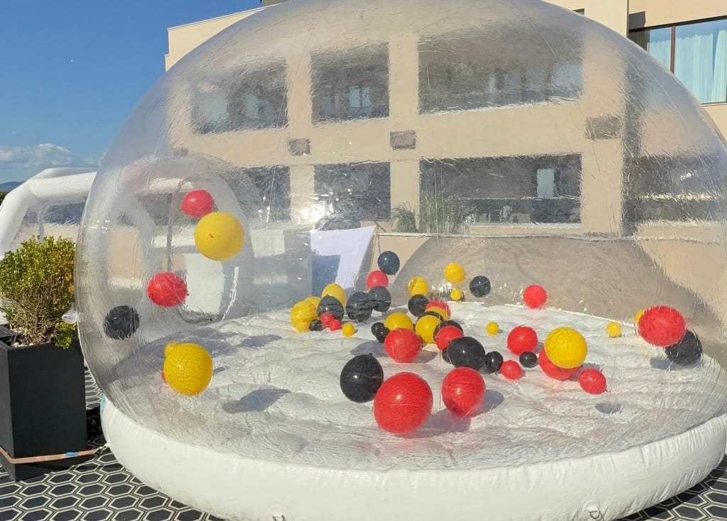 Διάφανος φουσκωτός θόλος bubble house της AdamsGames με μπαλόνια, στημένος στη στέγη πολυτελούς ξενοδοχείου στη Χαλκιδική
