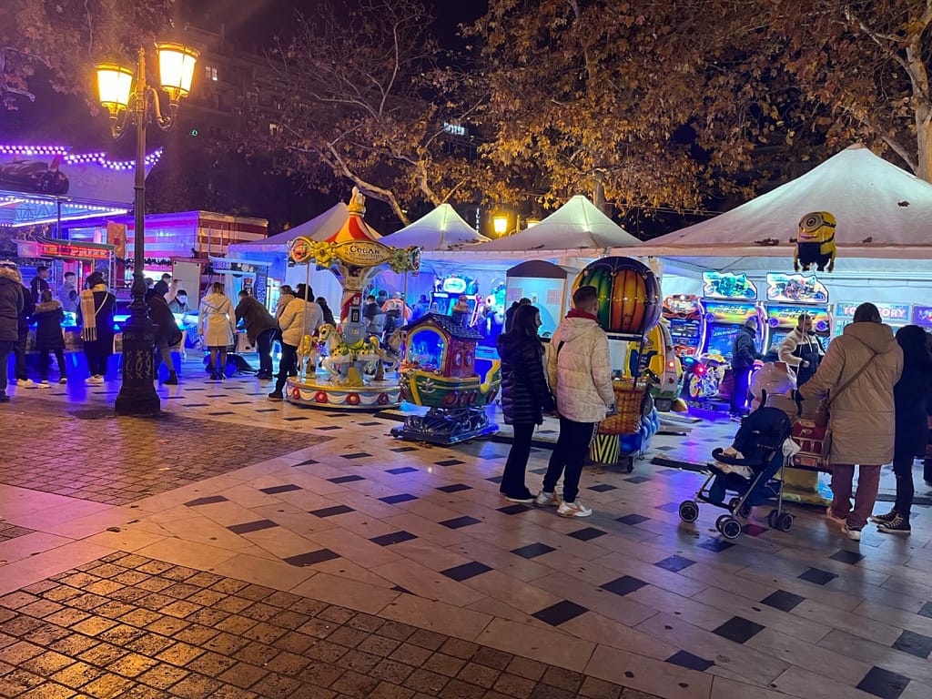 Λευκές τέντες με arcade μηχανήματα και καρουζέλ στην πλατεία Αριστοτέλους Θεσσαλονίκης το βράδυ