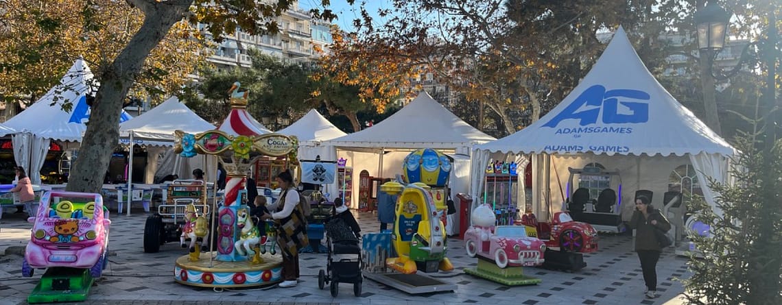 Λευκές τέντες AdamsGames και παιδικά μηχανήματα στο πλακόστρωτο της Πλατείας Αριστοτέλους στη Θεσσαλονίκη