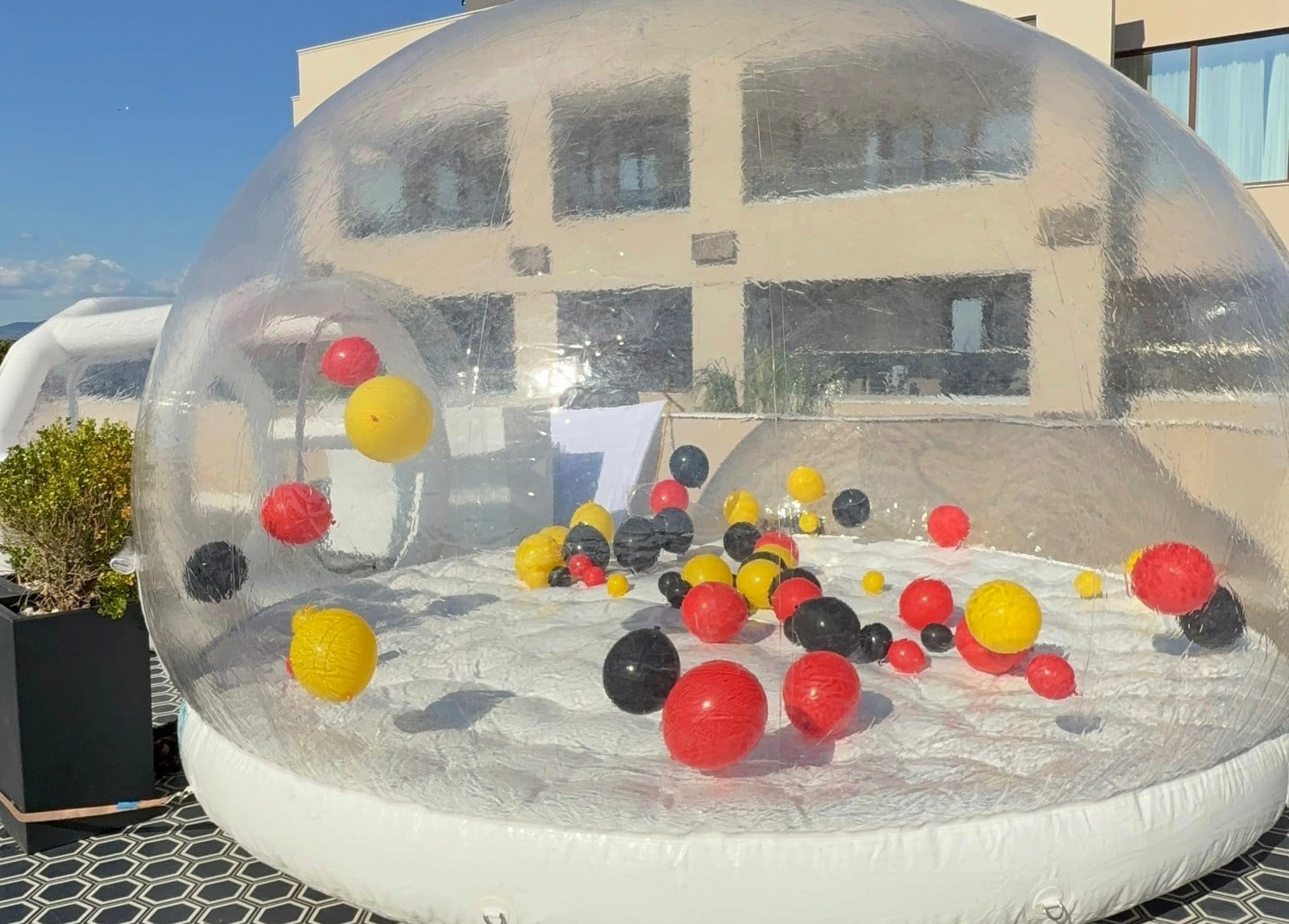 Διάφανος φουσκωτός θόλος bubble house της AdamsGames με μπαλόνια, στημένος στη στέγη πολυτελούς ξενοδοχείου στη Χαλκιδική