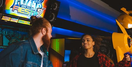 Παρέα διασκεδάζει σε arcade χώρο ψυχαγωγίας με neon φωτισμό