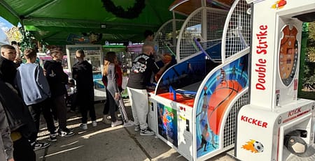 Πράσινη τέντα σε πλακόστρωτη πλατεία με μπασκέτες arcade και μηχάνημα σουτ, Δεκέμβριος 2024
