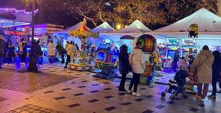 Λευκές τέντες με arcade μηχανήματα και καρουζέλ στην πλατεία Αριστοτέλους Θεσσαλονίκης το βράδυ