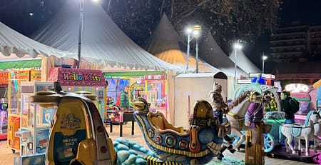 Φωτισμένα κουνιστά παιχνίδια και καρουζέλ κάτω από λευκές τέντες στη χριστουγεννιάτικη πλατεία Αριστοτέλους στη Θεσσαλονίκη, βράδυ
