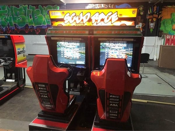 Scud Race Twin σε λειτουργία — διπλό αγωνιστικό μηχάνημα SEGA με φωτισμένη μαρκίζα