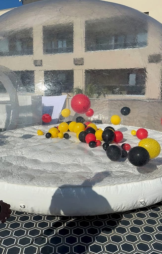 Κοντινή λήψη σε διάφανο φουσκωτό θόλο με κόκκινα, κίτρινα και μαύρα μπαλόνια, σε ιδιωτική εκδήλωση στη Χαλκιδική