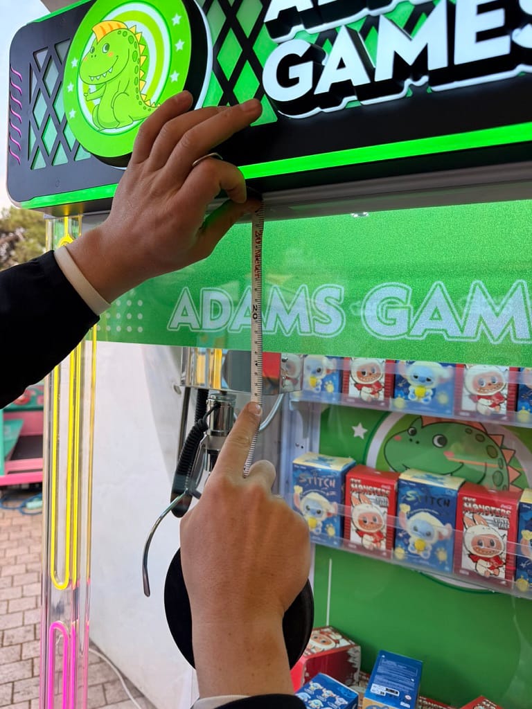 Μέτρηση κάτω από τη φωτιζόμενη πινακίδα ADAMS GAMES σε γερανό με έπαθλα